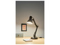 Une lampe de bureau noire avec un bras incurvé sur un bureau en bois.
