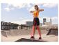 Femme faisant des exercices avec des bandes de résistance dans un skatepark.