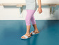 Un enfant portant un legging rose et des sandales blanches.