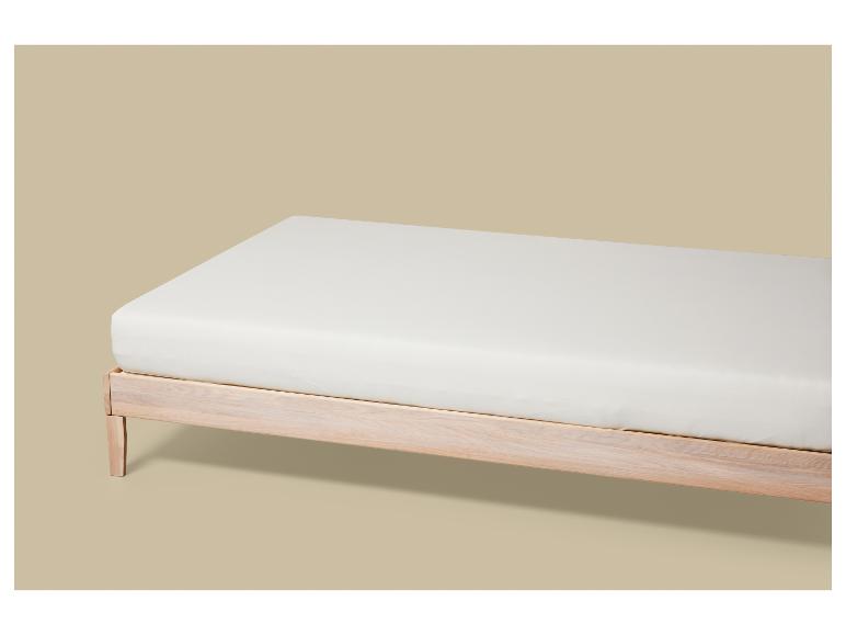 Un matelas blanc sur un cadre de lit en bois