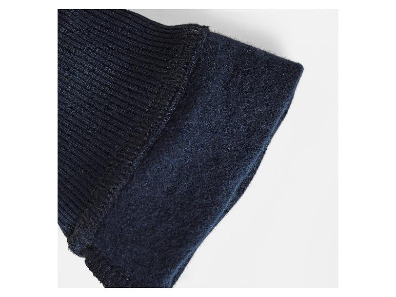 Détail du poignet d'une veste bleu marine à manches longues.