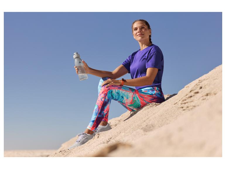 Femme en tenue de sport, avec leggings colorés et bouteille d'eau Close-Up.