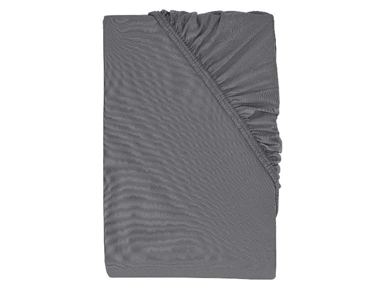 Drap-housse gris plié avec élastique.