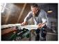Un homme utilise une scie plongeante Parkside pour couper du bois.