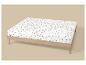 Drap-housse blanc à motif de champignons bruns sur un cadre de lit en bois clair.