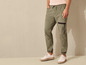 Un homme portant un pantalon cargo vert et des baskets blanches.