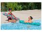 Deux femmes profitent de flotteurs fruités et turquoise au bord d'une piscine.