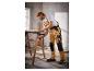 Un homme en vêtements de travail utilise une pince pour fixer du bois.