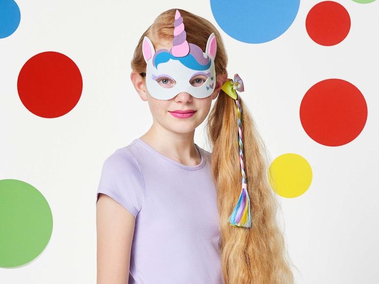 Une fille porte un masque de licorne avec un bandeau arc-en-ciel.