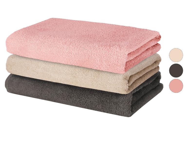 Ensemble de serviettes de bain roses, beiges et gris foncé.