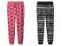 Deux pantalons de pyjama sur le thème de Noël : un rose avec des teckels et un noir avec un motif hivernal.
