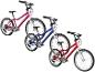 Trois vélos pour enfants roses, bleus et rouges, avec des vélos plus petits assortis.