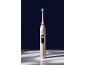 Brosse à dents électrique dorée avec tête bleue et verte, affichant 'Clean' sur l'écran.