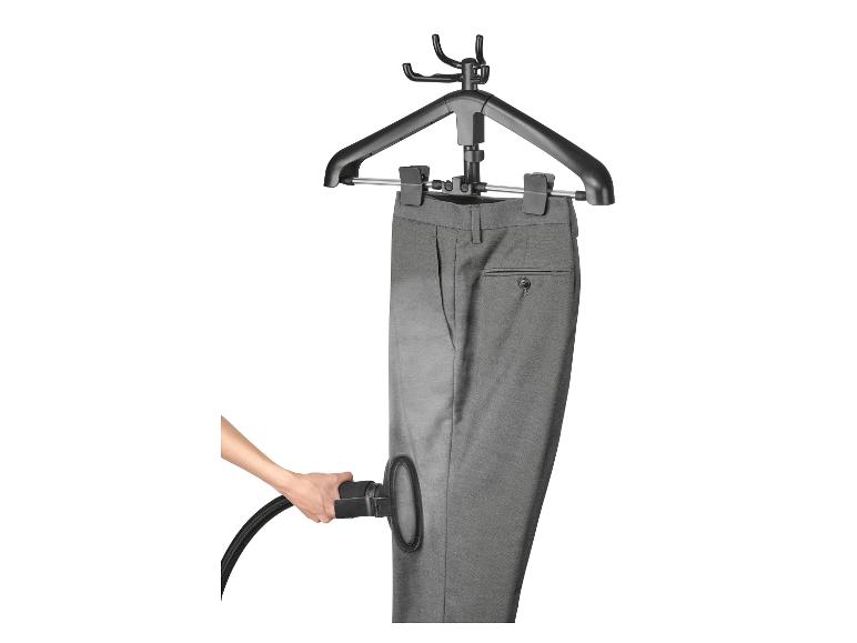 Pantalon gris sur cintre, défroissé avec un défroisseur à main.