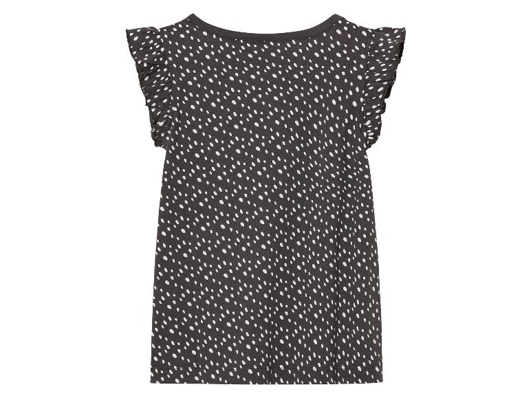 Une robe noire à pois blancs et des volants sur les manches.