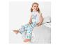 Une fille porte un pyjama blanc avec un motif de papillon et des fleurs roses et vertes.