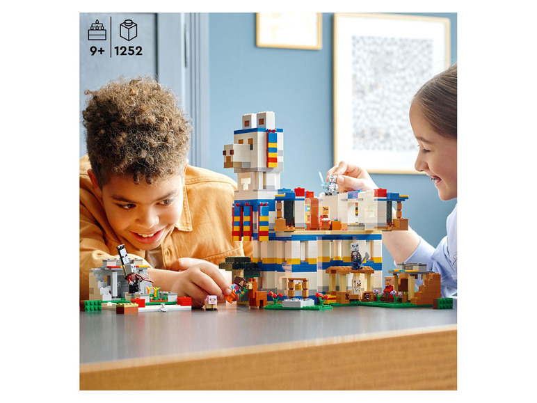Deux enfants construisent un set LEGO Minecraft avec un lama.