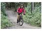 Une femme fait du vélo de montagne dans une forêt