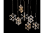 Décorations lumineuses de Noël en forme de flocons de neige sur fond noir.