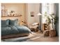 Chambre à coucher avec lit élégant, fauteuil et accessoires naturels.