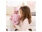 Fille jouant avec une poupée Baby Annabell vêtue d'un pyjama et d'une veste roses.