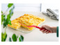 Une assiette de gratin dauphinois cuit au four est servie avec une spatule rouge.