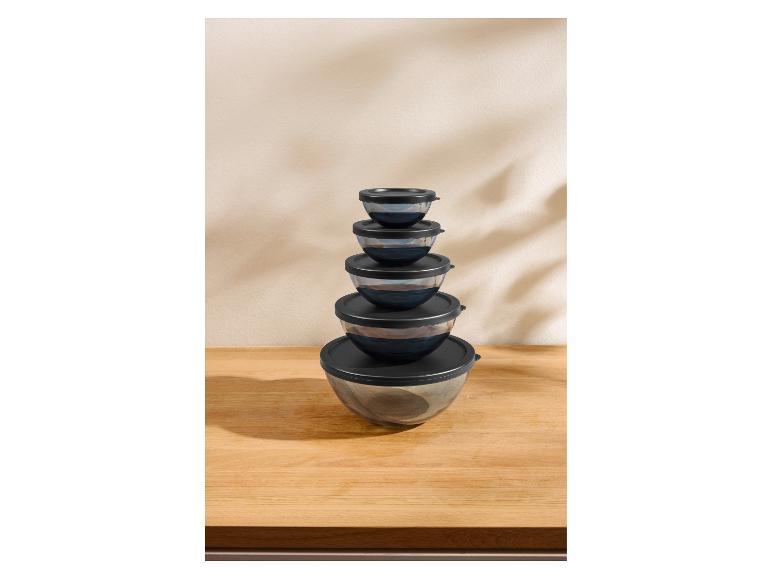 Ensemble de cinq bols en verre avec couvercles noirs, empilés les uns sur les autres.