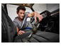 Un homme utilise un aspirateur Silvercrest pour nettoyer les sièges de la voiture.