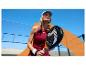 Femme avec raquette de padel en tenue de sport sur un court extérieur ensoleillé.