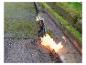Un chalumeau à gaz est utilisé pour réparer une fissure dans le trottoir.