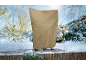 Housse de protection pour plantes dans un jardin enneigé, protégeant une plante du froid.