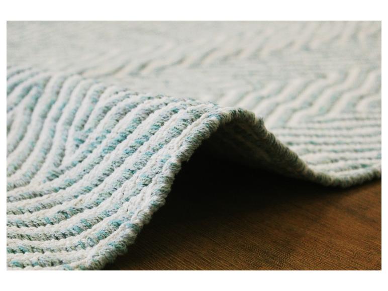 Gros plan d'un tapis blanc et turquoise avec un motif en zigzag.