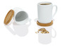 Deux tasses blanches avec des dessous de verre en bambou et des biscuits.