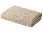 Serviette pliée beige avec une bordure à motifs