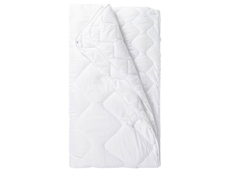Une couette blanche avec un motif en losange matelassé.