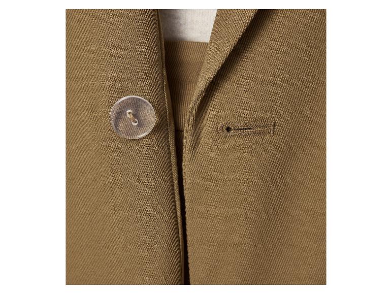 Gros plan d'une veste marron avec un bouton transparent et une boutonnière.
