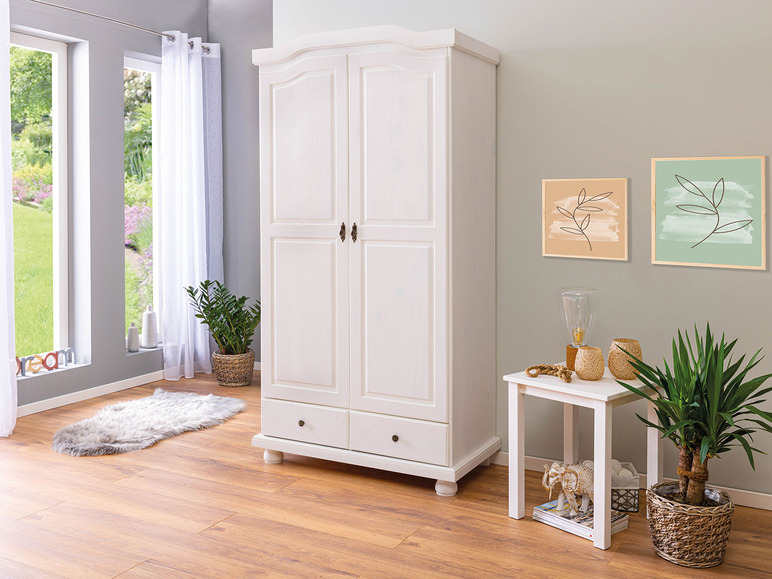 Une armoire blanche à deux portes et un tiroir, dans un salon moderne.