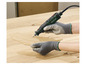 Une main utilise un outil multifonction Parkside pour travailler sur une feuille en bois.