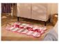 Tapis de bain rayé rose avec le texte «Sweet Bella» sur un sol en bois.