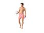 Un homme en maillot de bain rayé rose et orange tient un ballon de volley.