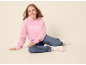 Fille en sweat à capuche rose avec 'ASPEN COLORADO' et jean assise souriante