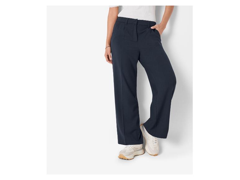 Pantalon large bleu marine et baskets blanches.