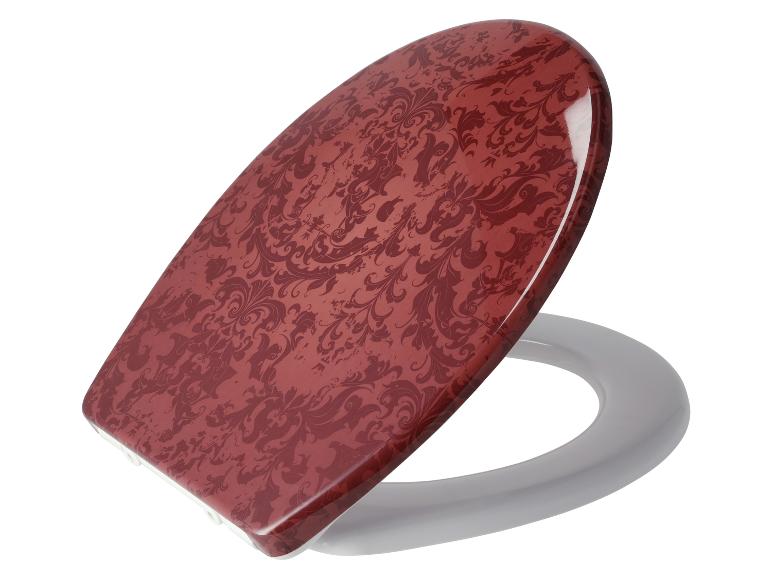 Un abattant de toilettes rouge bordeaux à motif damassé.