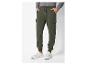 Un homme portant un jogging cargo vert avec des baskets blanches.