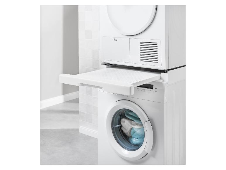 Lave-linge et sèche-linge superposés avec étagère coulissante dans une salle de bain blanche.