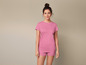 Une femme portant un t-shirt et un short roses.