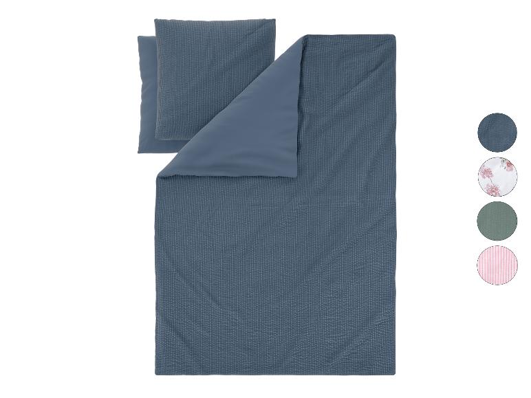 Parure de lit réversible bleue avec oreillers et échantillons de couleurs.