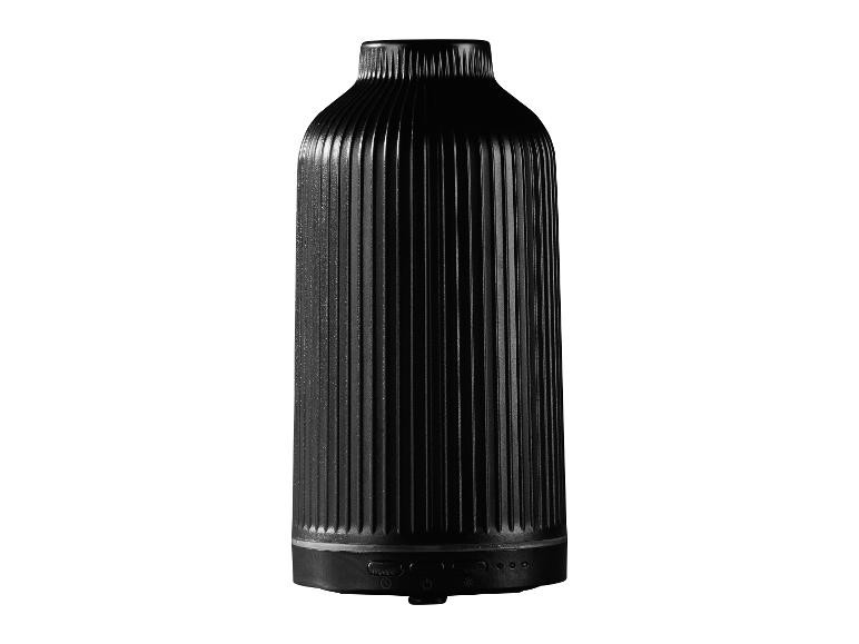 Diffuseur d'arômes noir avec un design cannelé et des boutons de commande à la base.