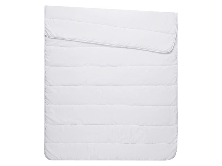 Couette ou couverture matelassée blanche, pliée sur le dessus.