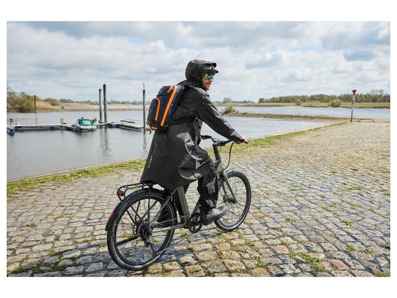 Homme à vélo sous la pluie portant un poncho de pluie premium CRIVIT noir.